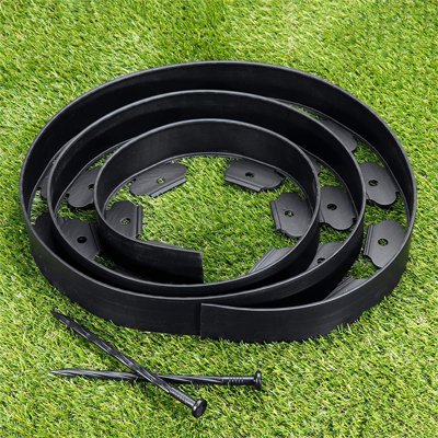 Bordure de jardin flexible enroulé sur elle-même et déposer sur faux gazon avec 2 piquets