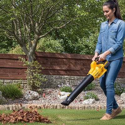 femme qui jardine avec Souffleur feuille pour feuille sur terrain