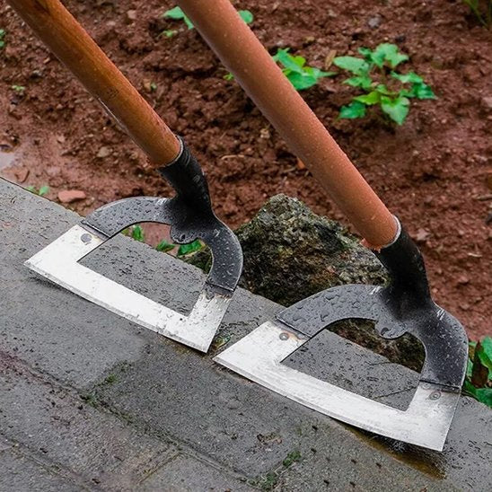 Binette de jardinage creuse avec long manche en bois, posée sur un sol en ciment
