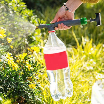 Pulverisateur gris avec bouteille de plastique enu par main arrosant une haie avec bruine