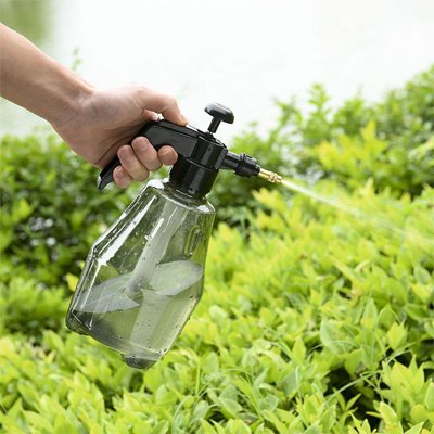 Pulverisateur professionel gris arrosant  plantes vertes avec jet directionnel  