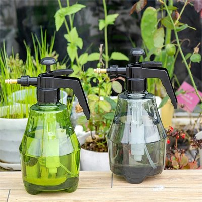 Pulverisateur professionel vert et gris déposé sur la table devant fleur