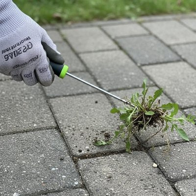 Desherbeur manuel utilisé par personne entre les dalles en béton