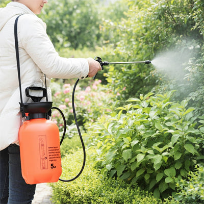 pulverisateur a main orange accrocher sur epaule  brumisant plantes