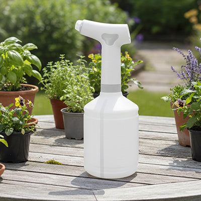 pulverisateur  electrique epose sur table entoure  plante en pot
